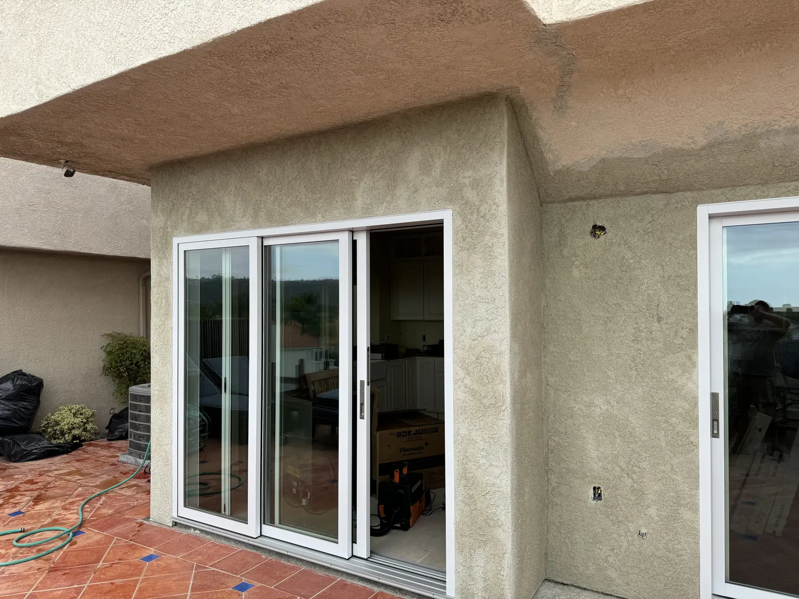 After: the same exterior wall finished in stucco with the sliding glass door installed