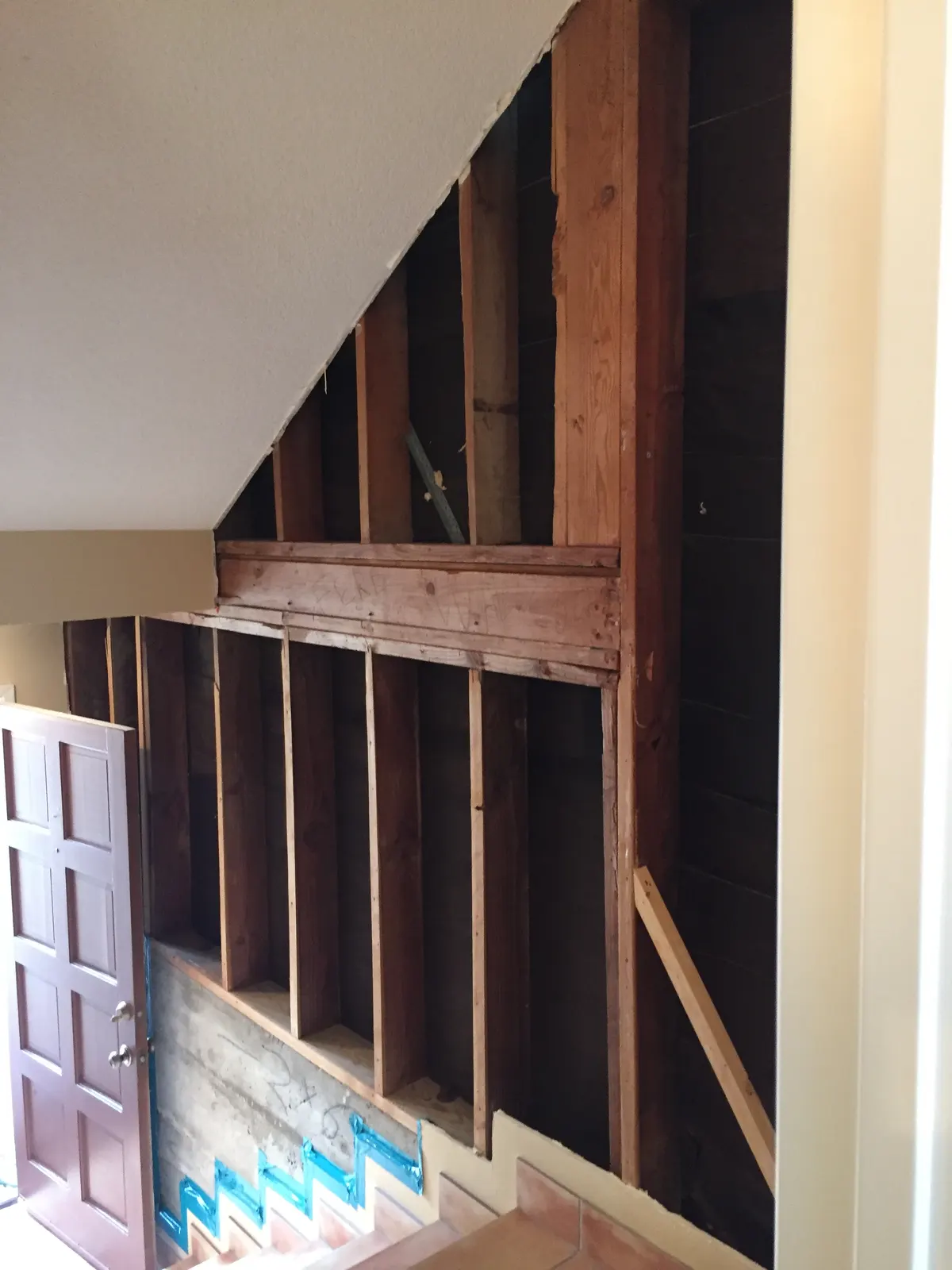Stairway wall opened to the studs from floor to ceiling
