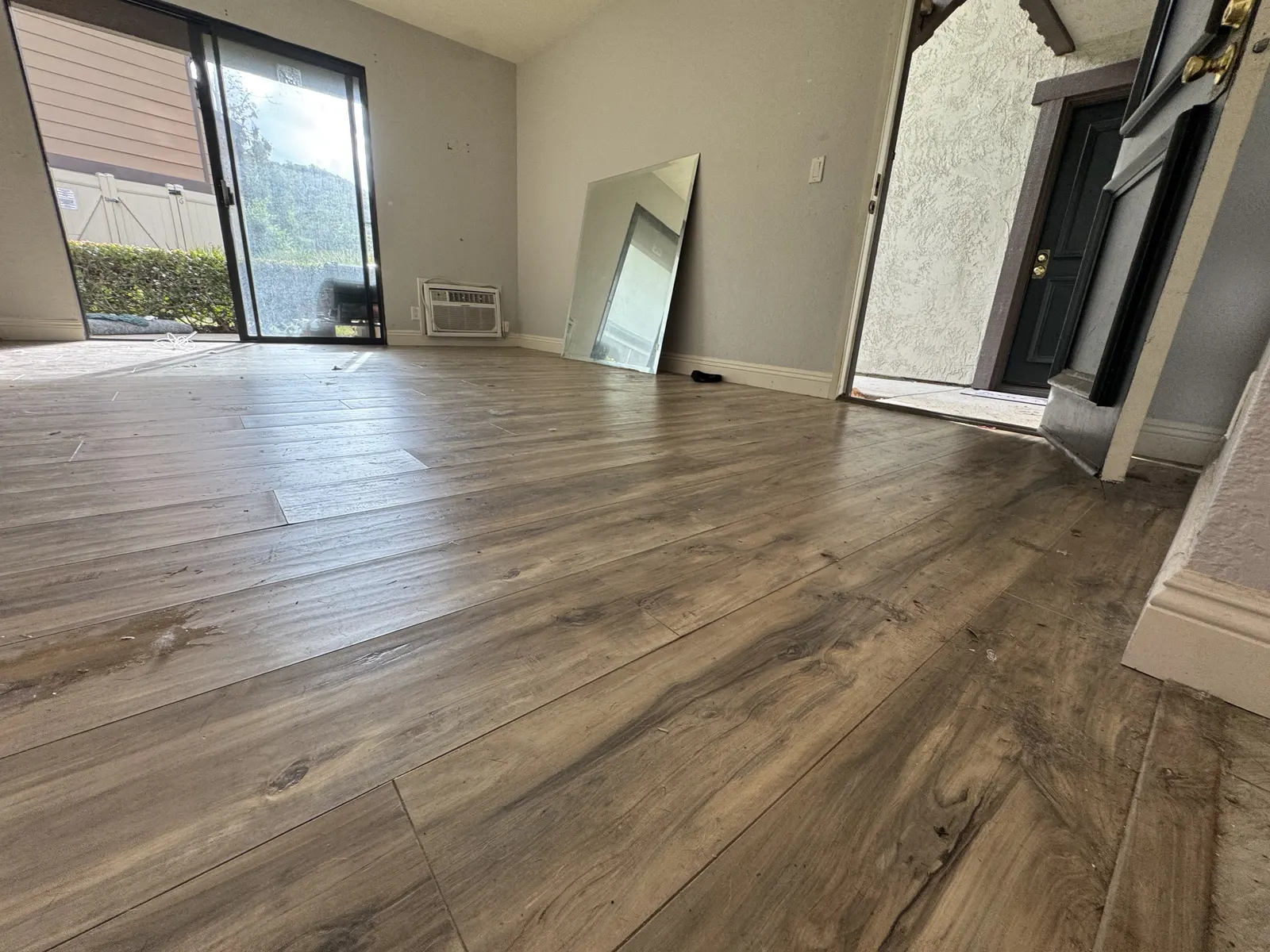 Room with new wood-look plank flooring and a sliding glass door