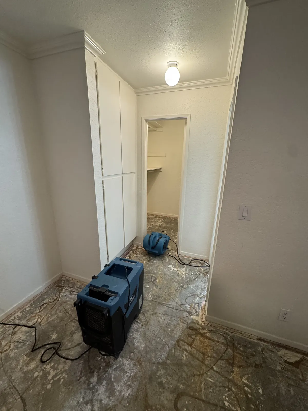 Hallway with flooring removed and drying equipment placed on the subfloor