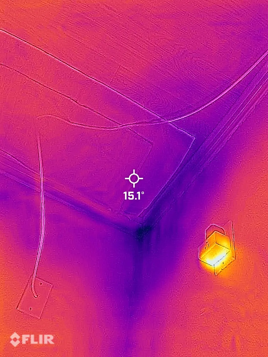 Thermal camera image of a wall and ceiling corner showing a cooler area