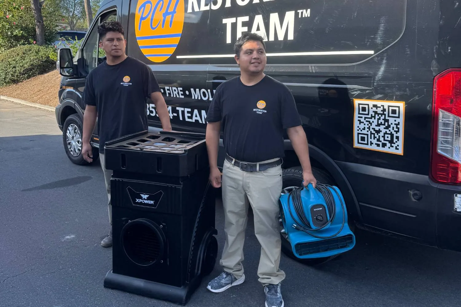 PCH Restoration Team technicians with an XPOWER air scrubber and air mover beside a PCH response van