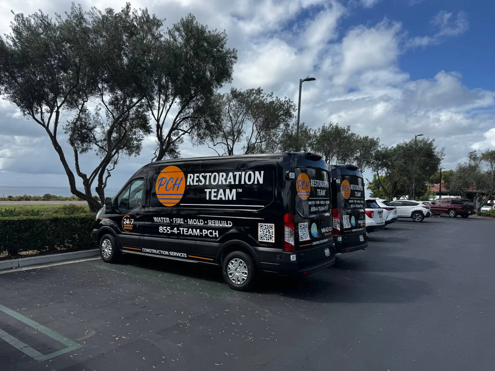 Two PCH Restoration Team response vans parked along the Orange County coast