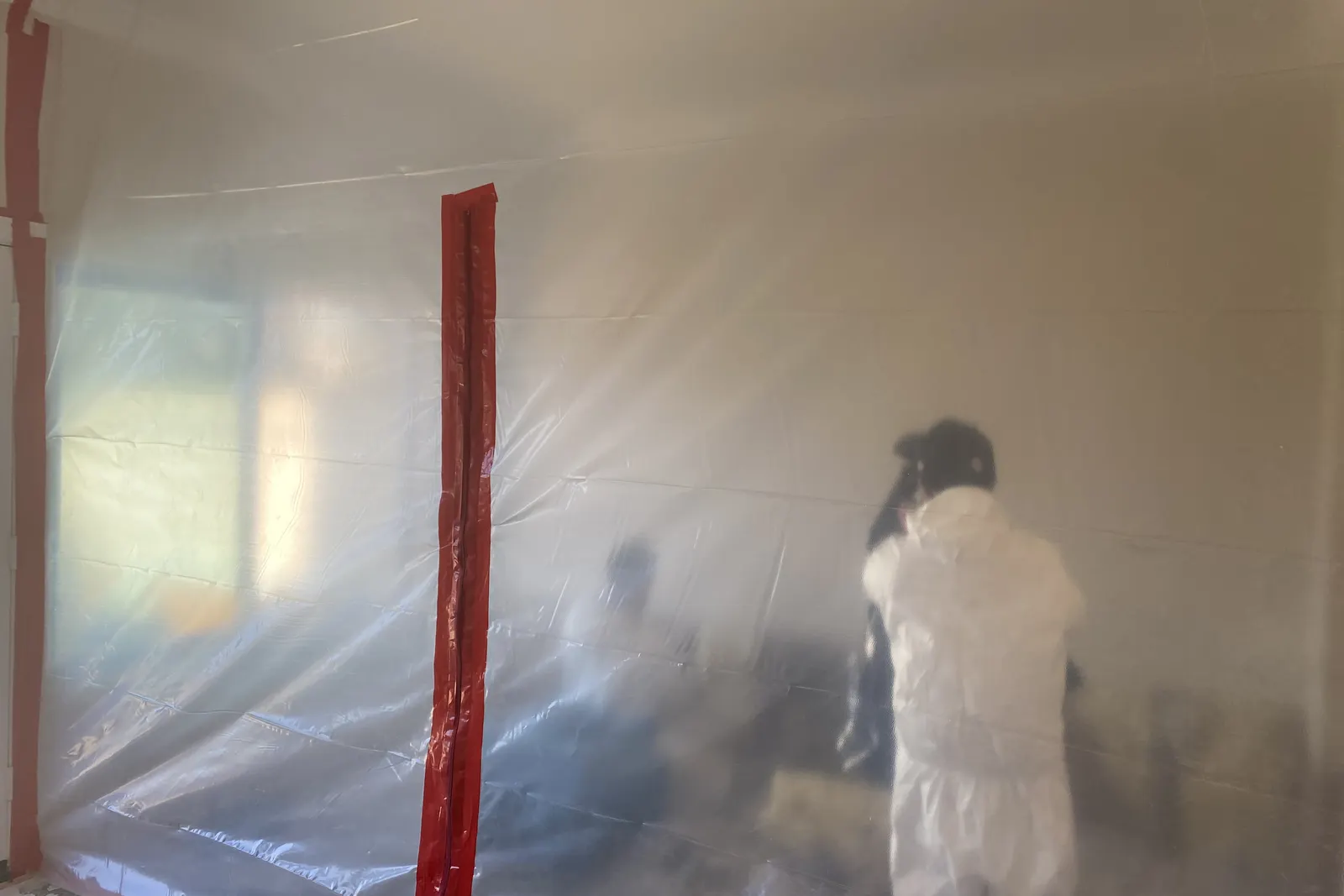 PCH Restoration Team technicians in protective suits working behind plastic containment sheeting during mold remediation